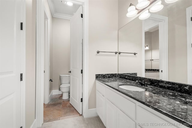 bathroom with vanity, toilet, and ornamental molding