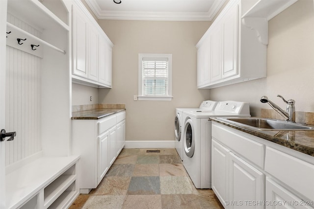 laundry area featuring washing machine and clothes dryer, sink, cabinets, and ornamental molding