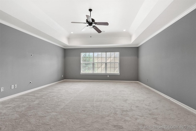 spare room with light carpet, a raised ceiling, ceiling fan, and crown molding