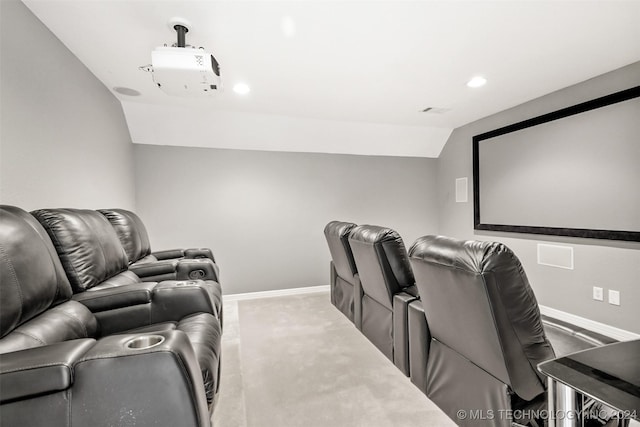 home theater with light colored carpet and vaulted ceiling