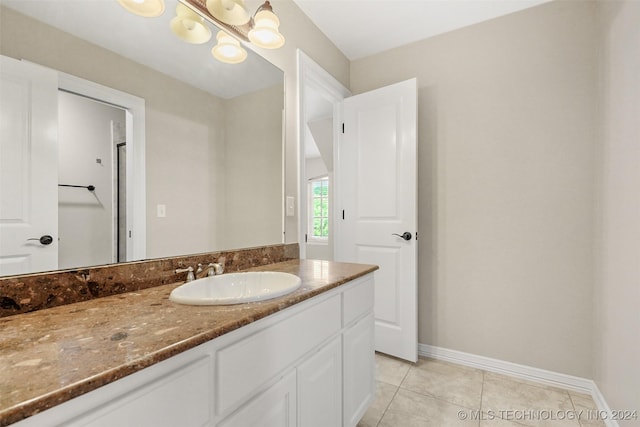 bathroom with tile patterned floors, vanity, and a notable chandelier