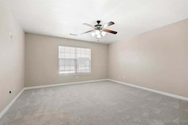 carpeted spare room with ceiling fan