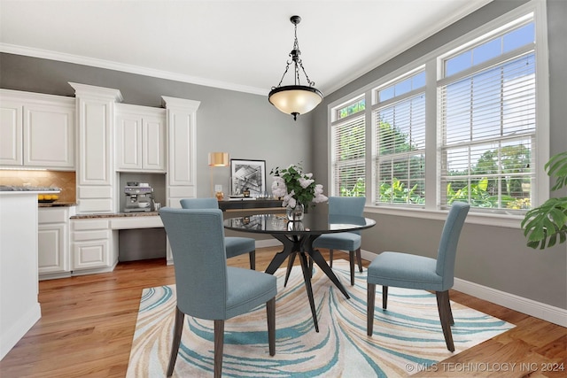 dining area featuring a healthy amount of sunlight, crown molding, and light hardwood / wood-style flooring