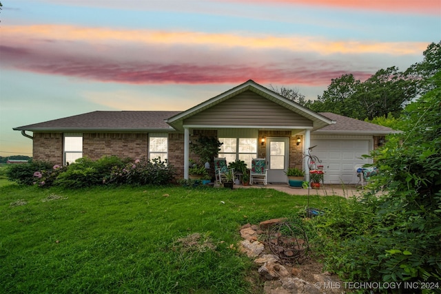 ranch-style house with a garage and a yard