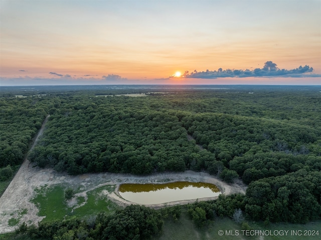 aerial view at dusk featuring a water view