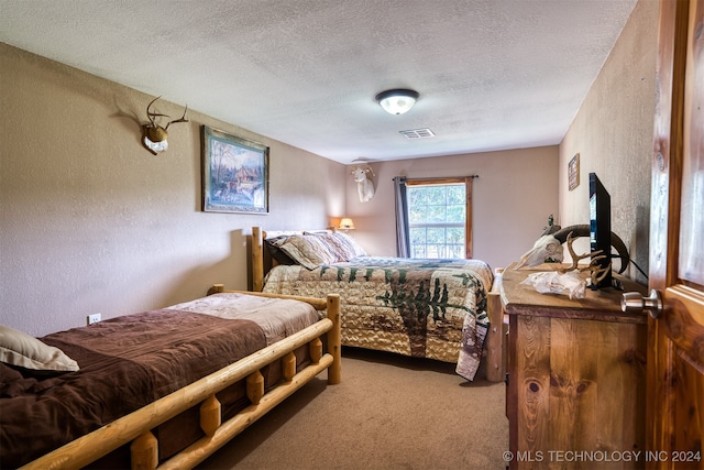 bedroom featuring a textured ceiling and carpet floors