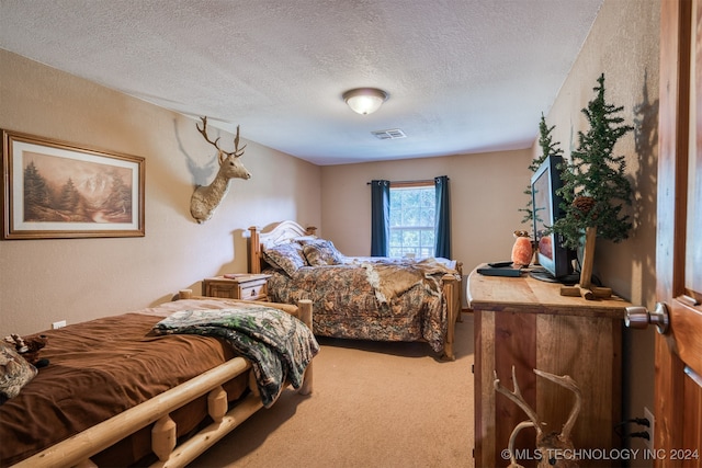 bedroom with carpet floors and a textured ceiling