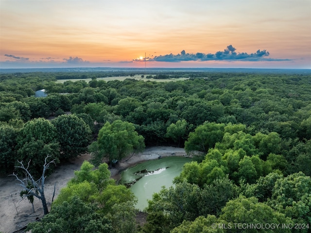 aerial view at dusk featuring a water view