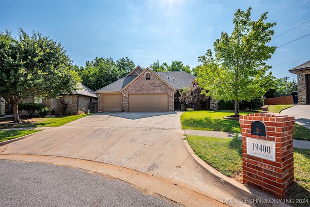 ranch-style house featuring a garage and a front lawn