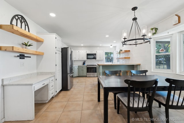 dining area featuring a healthy amount of sunlight, light tile patterned floors, and an inviting chandelier