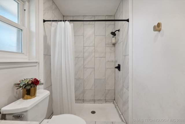 bathroom featuring a shower with curtain and toilet