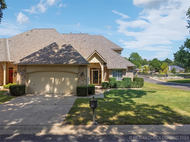 view of front of home with a garage and a front lawn