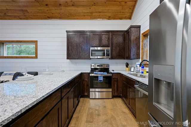 kitchen featuring sink, light hardwood / wood-style flooring, appliances with stainless steel finishes, dark brown cabinetry, and light stone countertops