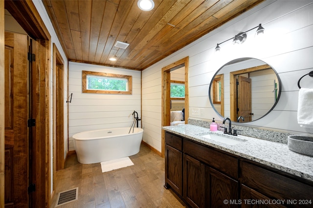 bathroom with wood walls, wood-type flooring, a tub, vanity, and wooden ceiling