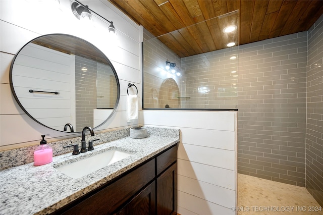 bathroom with vanity, wood ceiling, and a tile shower