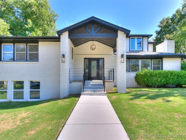 property entrance featuring a lawn