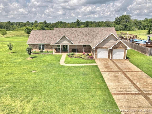 ranch-style house featuring a garage and a front lawn