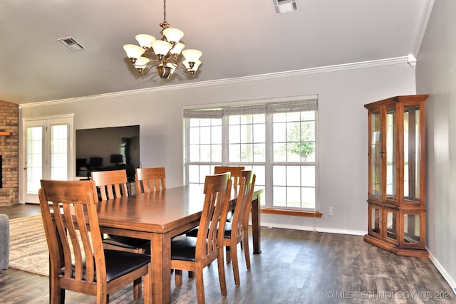 dining space with dark wood-type flooring, ornamental molding, and a chandelier