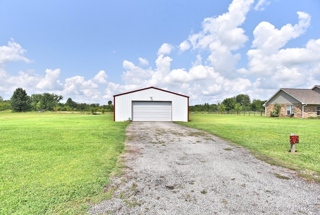 garage with a rural view and a lawn