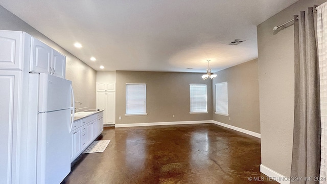 kitchen featuring white cabinets, white fridge, and an inviting chandelier