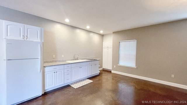 kitchen featuring white cabinets, white fridge, and sink