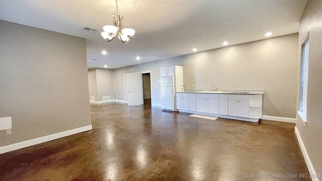 empty room featuring a notable chandelier and sink