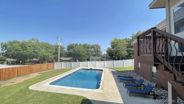 view of pool featuring a patio area and a yard