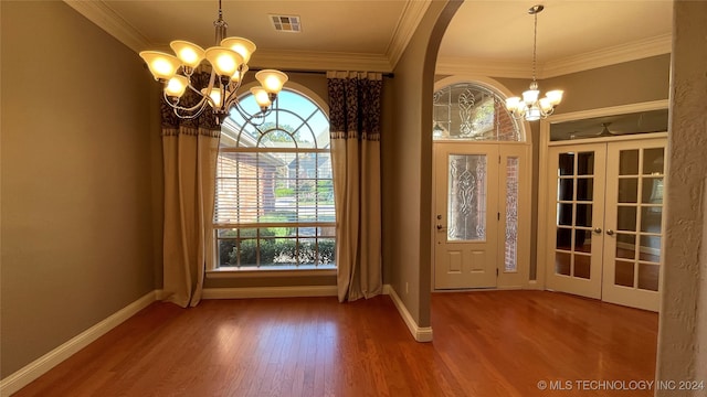 interior space featuring french doors, hardwood / wood-style flooring, an inviting chandelier, and ornamental molding