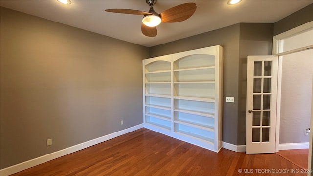 empty room with ceiling fan, french doors, and wood-type flooring