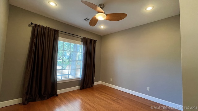 spare room featuring hardwood / wood-style flooring and ceiling fan