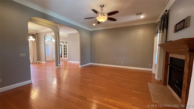 unfurnished living room with hardwood / wood-style floors, ceiling fan with notable chandelier, and ornamental molding