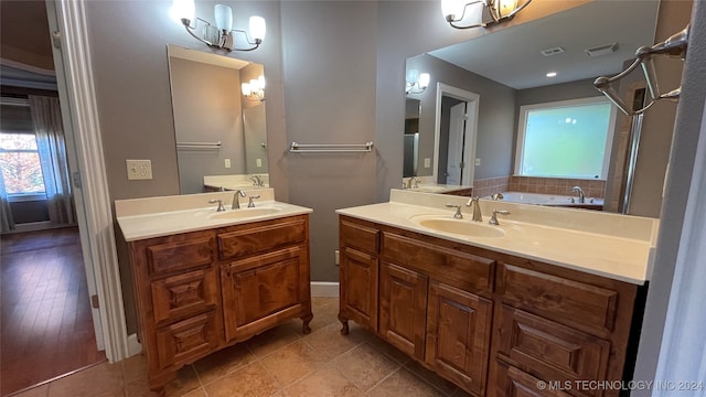 bathroom featuring a bathing tub, vanity, a notable chandelier, and hardwood / wood-style flooring