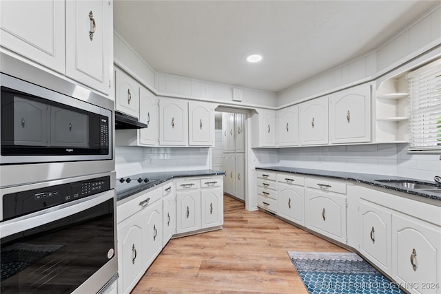 kitchen with tasteful backsplash, white cabinets, stainless steel appliances, light hardwood / wood-style floors, and sink