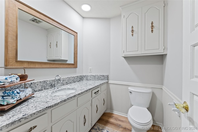 bathroom featuring vanity, wood-type flooring, and toilet