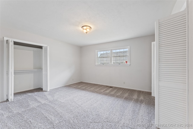 unfurnished bedroom featuring a closet and carpet flooring