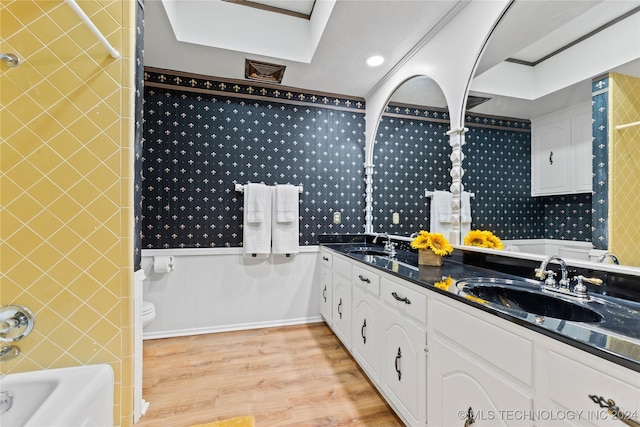 bathroom with vanity, toilet, hardwood / wood-style floors, and a washtub