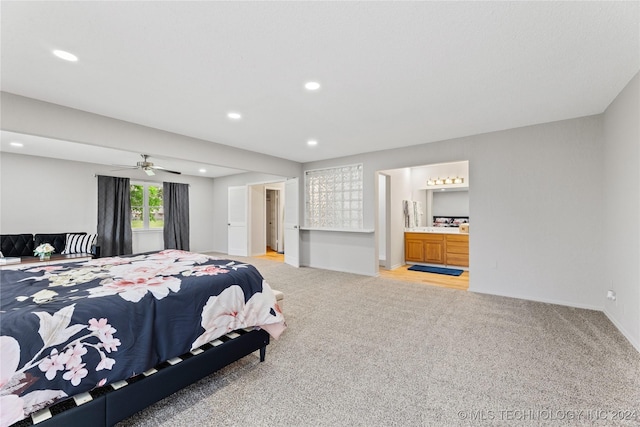 bedroom featuring light carpet and ensuite bath