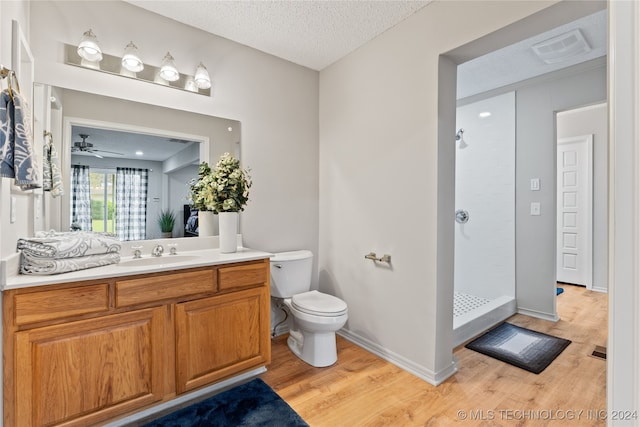 bathroom featuring a textured ceiling, toilet, vanity, ceiling fan, and wood-type flooring