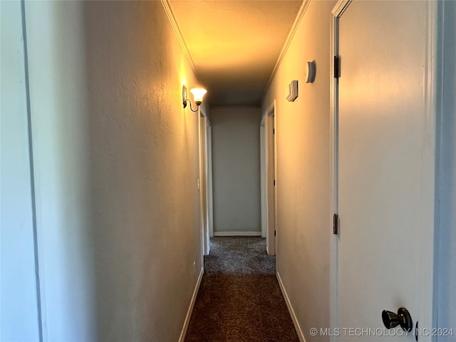 hallway featuring dark carpet and ornamental molding