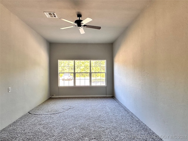 unfurnished room featuring ceiling fan and carpet