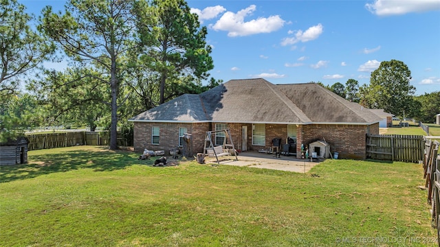 rear view of property featuring a yard and a patio area