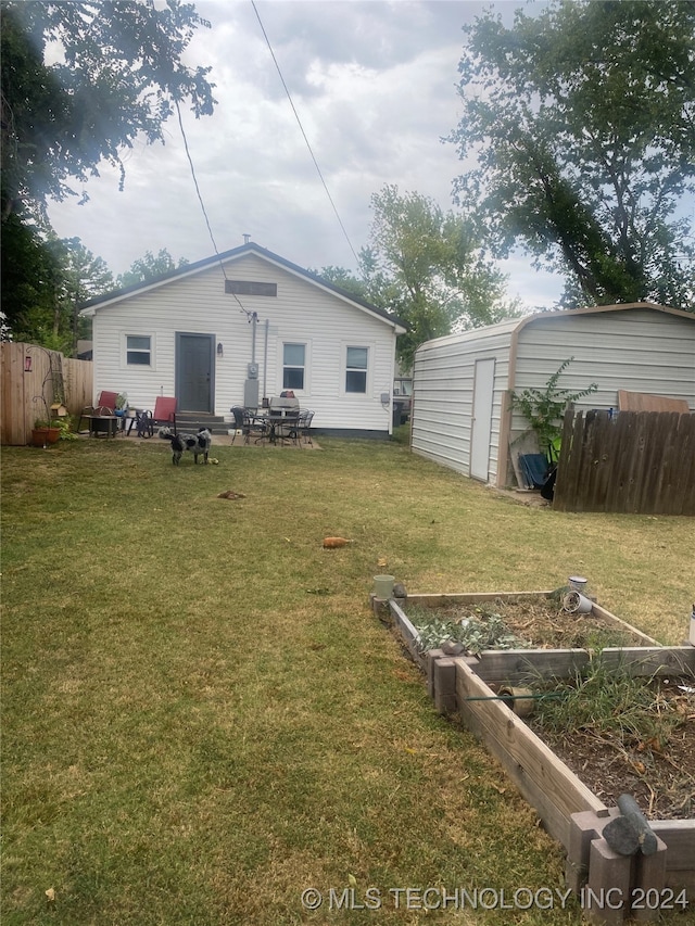 rear view of house featuring an outbuilding and a yard