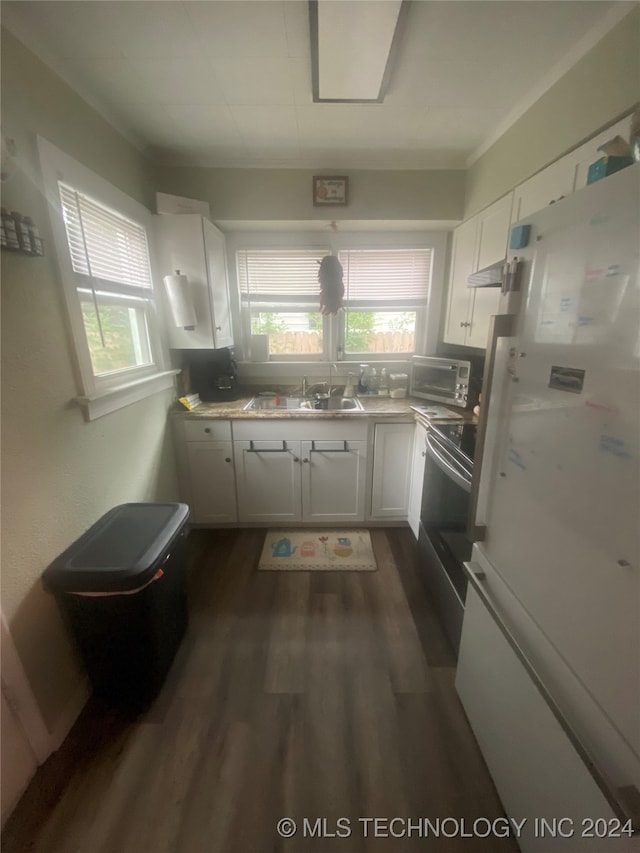 kitchen featuring dark hardwood / wood-style floors, white cabinetry, stove, white fridge, and sink