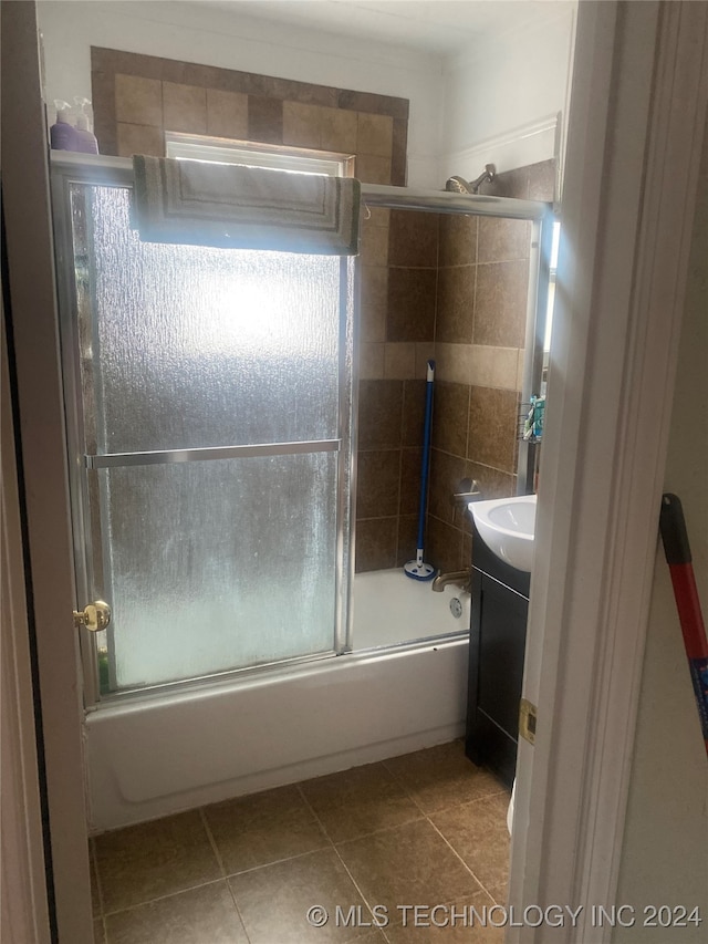 bathroom with combined bath / shower with glass door, vanity, tile patterned floors, and a healthy amount of sunlight