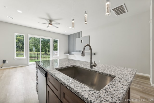 kitchen with light stone counters, ceiling fan, stainless steel dishwasher, light wood-type flooring, and sink