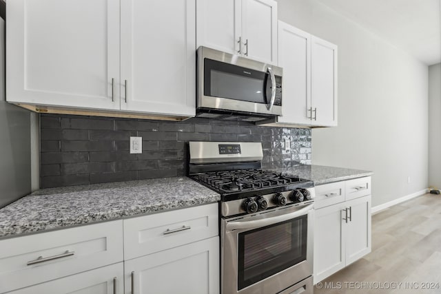 3408 Redbud Ln, Tulsa, OK 74132 - kitchen with stainless steel appliances, backsplash, light stone counters, and white cabinetry