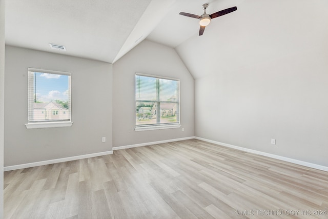 spare room with ceiling fan, light wood-type flooring, and vaulted ceiling