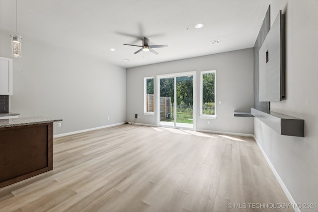 unfurnished living room featuring ceiling fan and light hardwood / wood-style floors