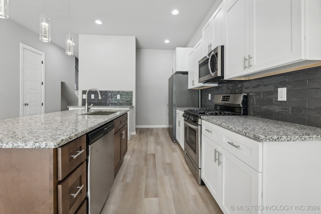 3408 Redbud Ln, Tulsa, OK 74132 - kitchen with appliances with stainless steel finishes, a sink, light wood-style floors, tasteful backsplash, and light stone counters