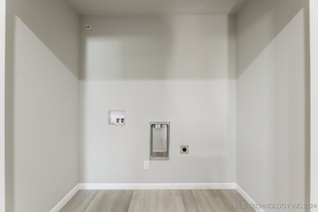 laundry area with light wood-type flooring, hookup for a washing machine, and electric dryer hookup